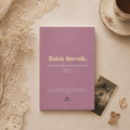 Purple notebook titled 'Bakin dnevnik' on a decorative surface with lace, flowers, and a teacup.
